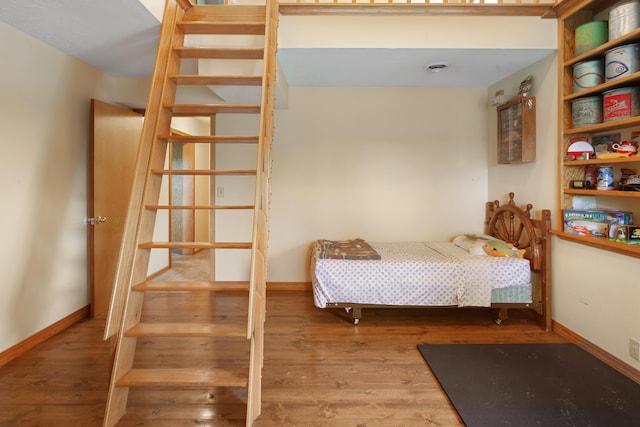 bedroom featuring baseboards and wood finished floors