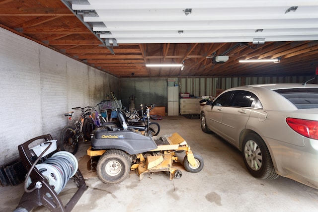 garage with a garage door opener and white refrigerator