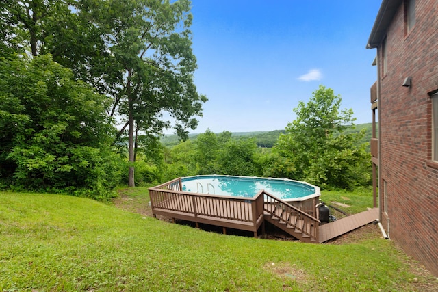 outdoor pool featuring a wooden deck and a yard