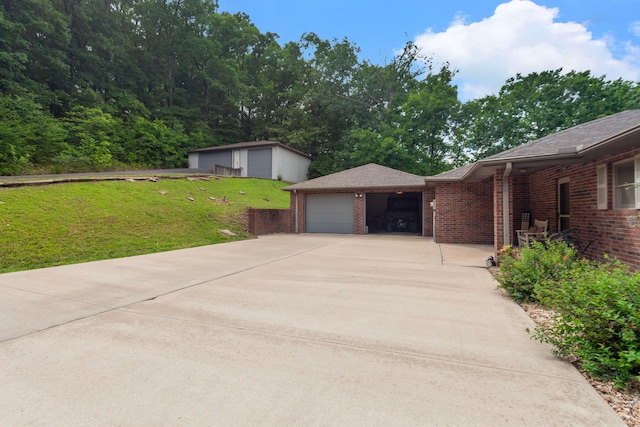 view of side of home featuring brick siding, a yard, driveway, and a garage