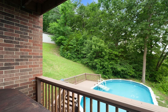 outdoor pool with a yard and a deck