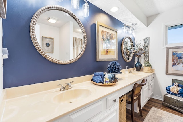 bathroom featuring hardwood / wood-style floors, vanity, and a textured ceiling