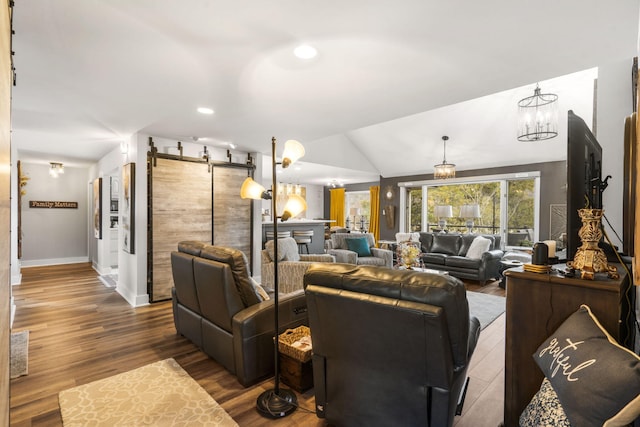 living room featuring an inviting chandelier, lofted ceiling, and hardwood / wood-style flooring