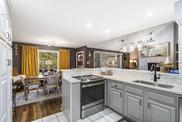 kitchen with sink, light tile patterned floors, pendant lighting, gray cabinets, and stainless steel electric range