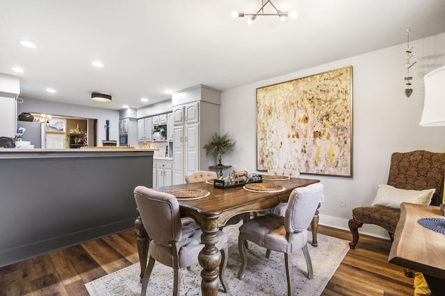 dining space featuring dark wood-type flooring and an inviting chandelier