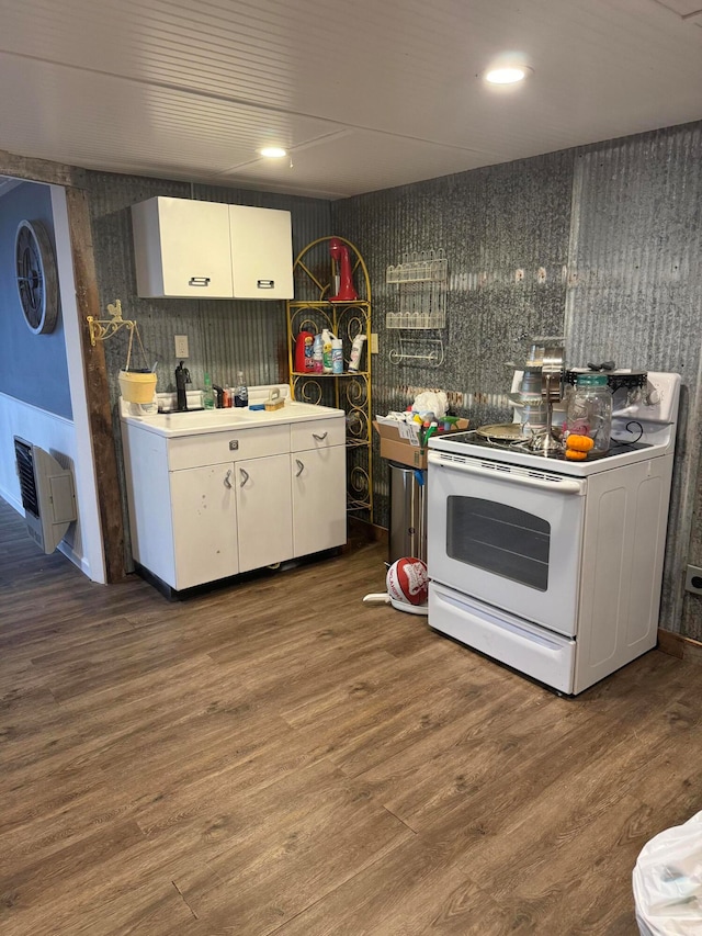 kitchen with electric stove, dark hardwood / wood-style floors, and white cabinets