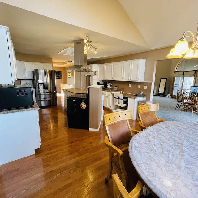 dining area featuring high vaulted ceiling and dark hardwood / wood-style flooring