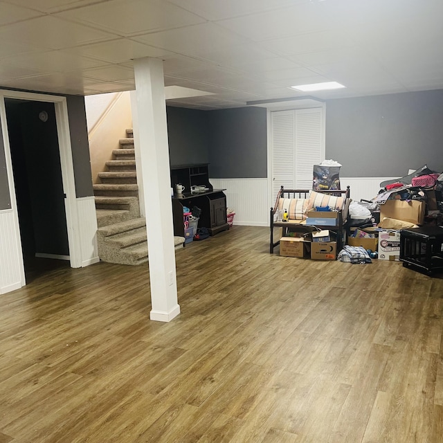 basement with a paneled ceiling and hardwood / wood-style floors