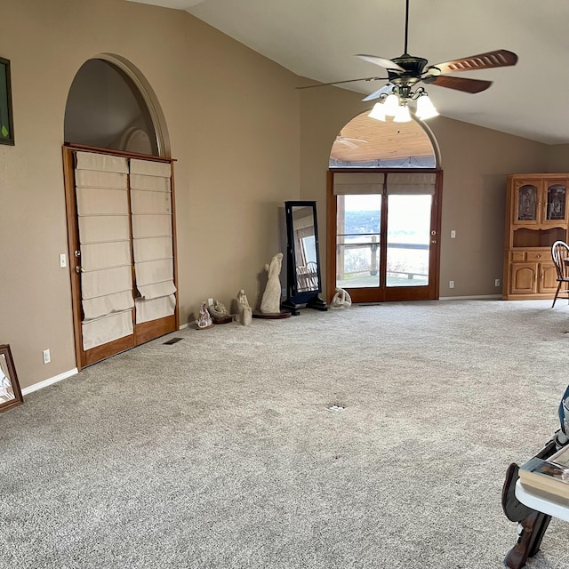 unfurnished living room featuring ceiling fan, carpet flooring, and vaulted ceiling