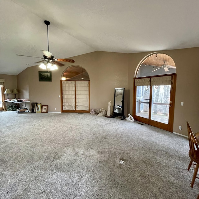 unfurnished living room featuring ceiling fan, vaulted ceiling, and carpet