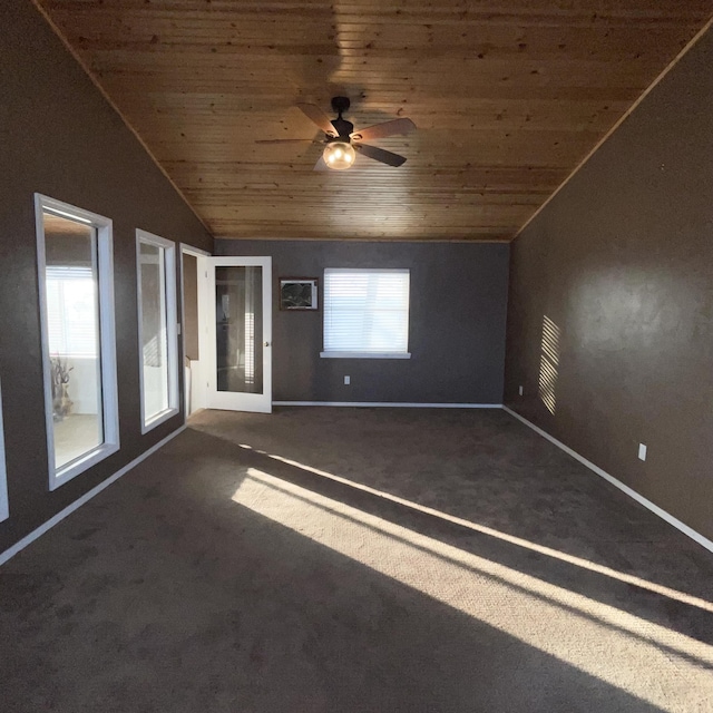 empty room with dark carpet, wood ceiling, and a healthy amount of sunlight