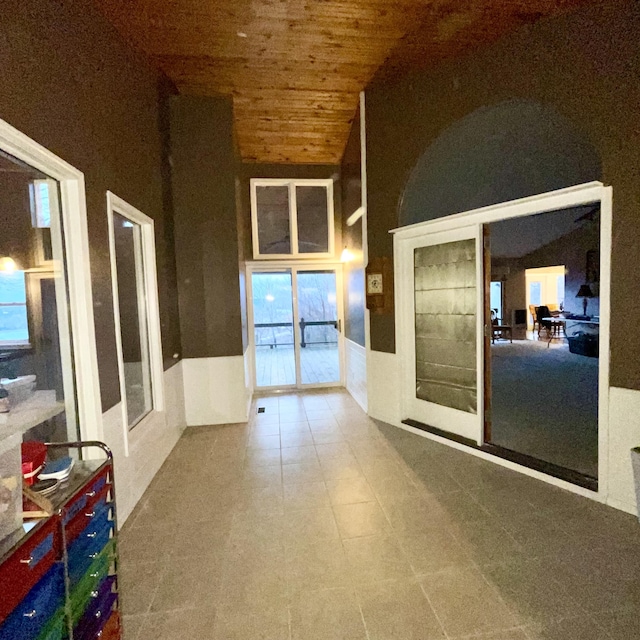 interior space featuring lofted ceiling, wooden ceiling, and french doors