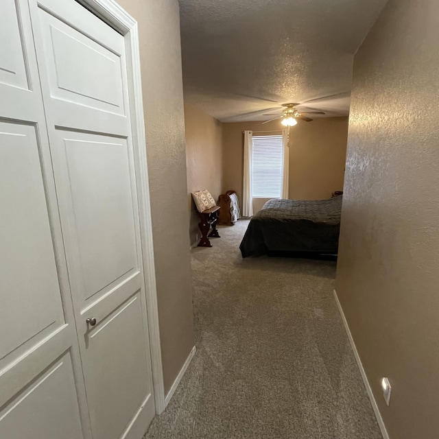 carpeted bedroom featuring a textured ceiling and ceiling fan