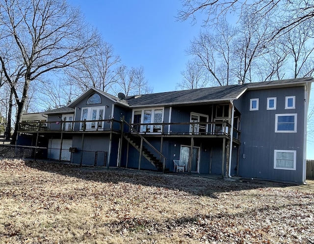 rear view of property featuring a garage and a deck