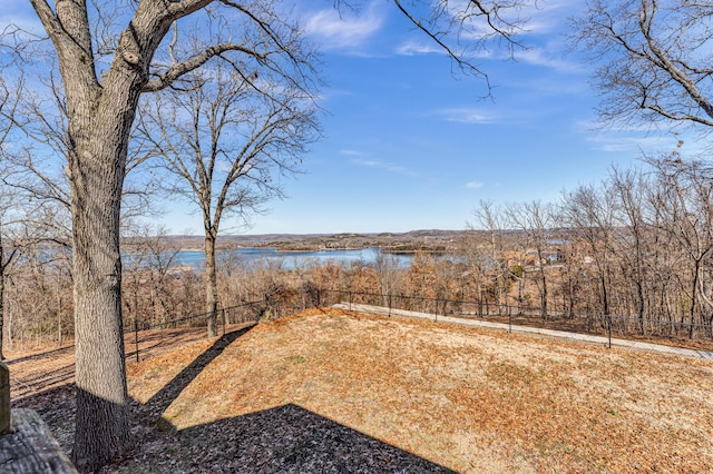 view of yard featuring a water view and fence