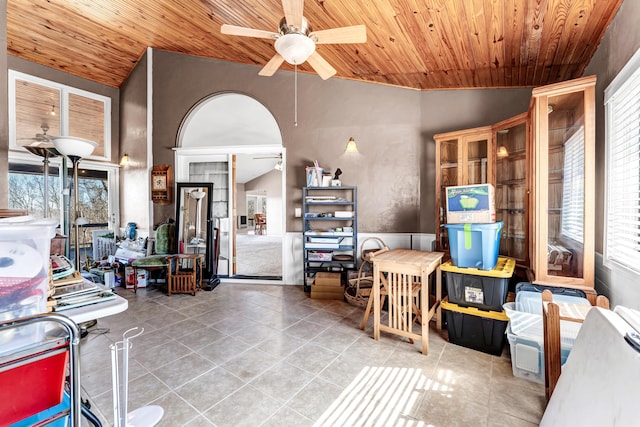 interior space featuring a ceiling fan, tile patterned flooring, wood ceiling, and vaulted ceiling