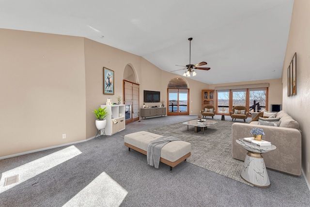 living room featuring lofted ceiling, visible vents, a ceiling fan, carpet flooring, and baseboards