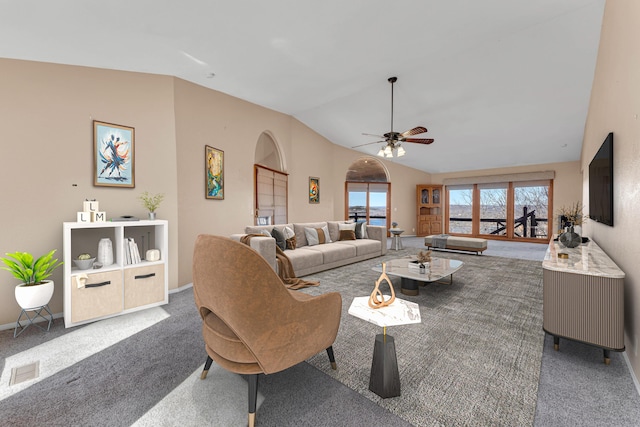 living room featuring baseboards, visible vents, a ceiling fan, vaulted ceiling, and carpet floors