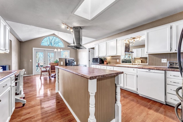 kitchen with white dishwasher, light wood-style flooring, a sink, range hood, and stainless steel range with electric stovetop