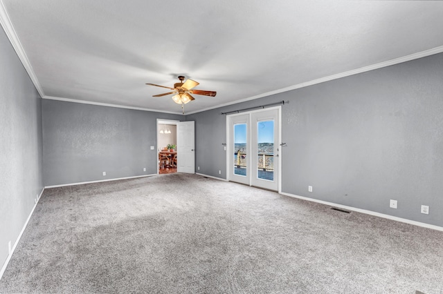 carpeted spare room featuring ceiling fan, a textured wall, ornamental molding, and baseboards