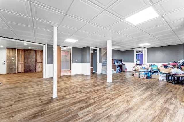 finished basement with stairway and wood finished floors