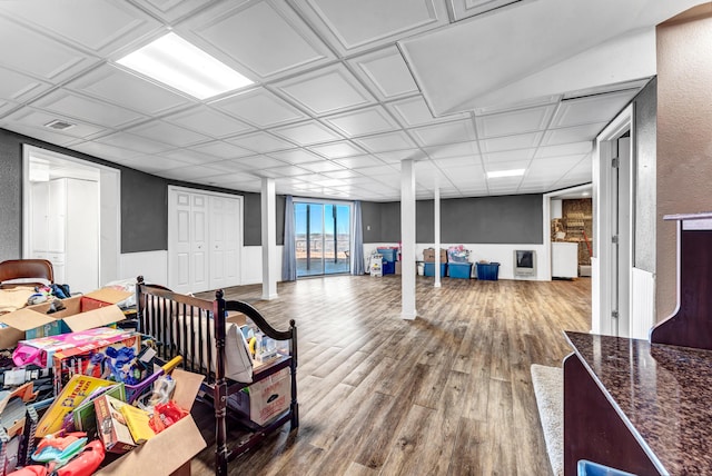 interior space with a wainscoted wall, a textured wall, wood finished floors, and an ornate ceiling