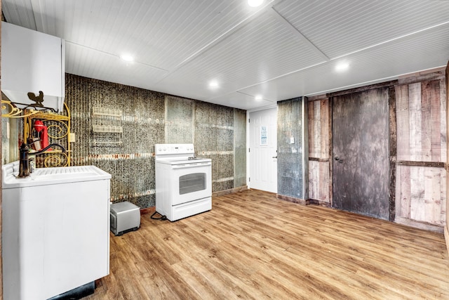 kitchen featuring light wood finished floors, white range with electric stovetop, a sink, and independent washer and dryer