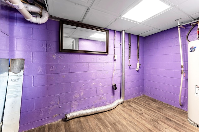 interior space featuring concrete block wall, water heater, and light wood-style flooring