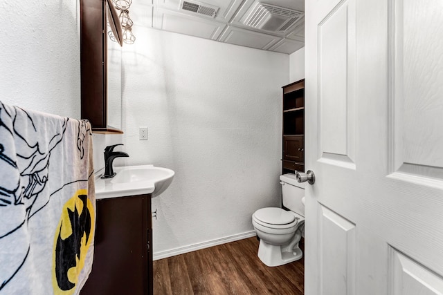 bathroom featuring toilet, baseboards, visible vents, and wood finished floors