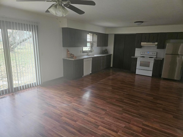 kitchen with light stone countertops, ceiling fan, dark hardwood / wood-style floors, white appliances, and sink