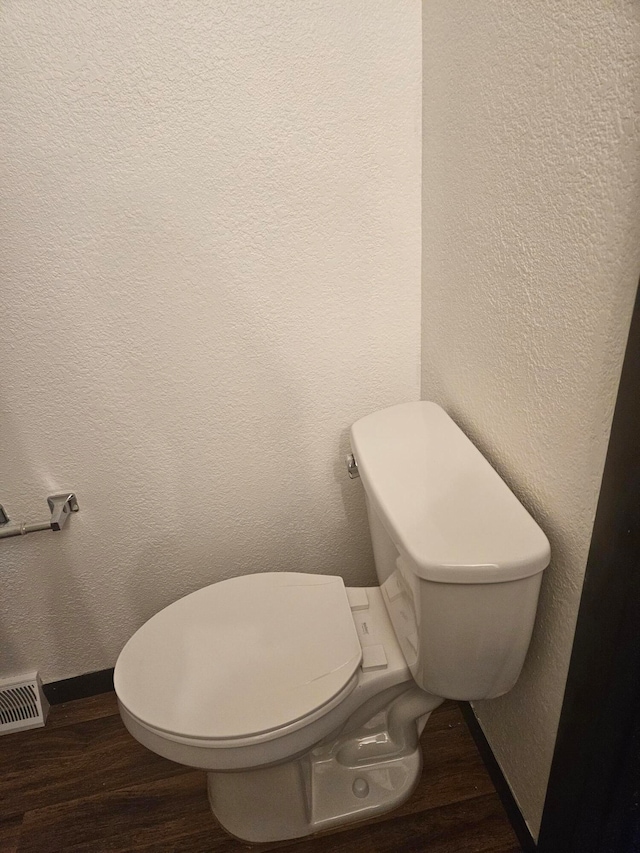 bathroom with hardwood / wood-style floors and toilet