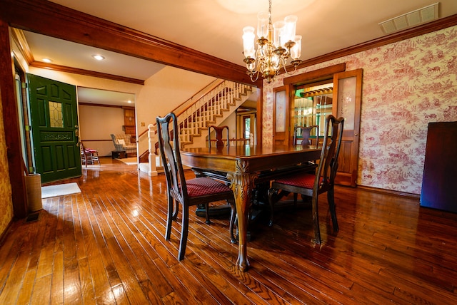 dining room with wood-type flooring, an inviting chandelier, and crown molding