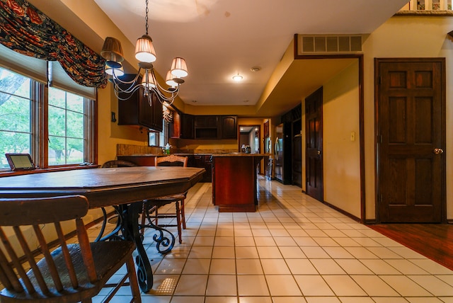 kitchen featuring dark brown cabinetry, decorative light fixtures, light hardwood / wood-style flooring, and a chandelier