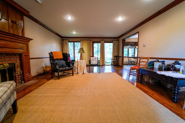 sitting room with ornamental molding, a brick fireplace, and dark hardwood / wood-style flooring