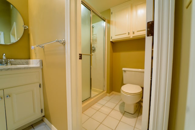 bathroom with toilet, tile patterned flooring, vanity, and a shower with shower door