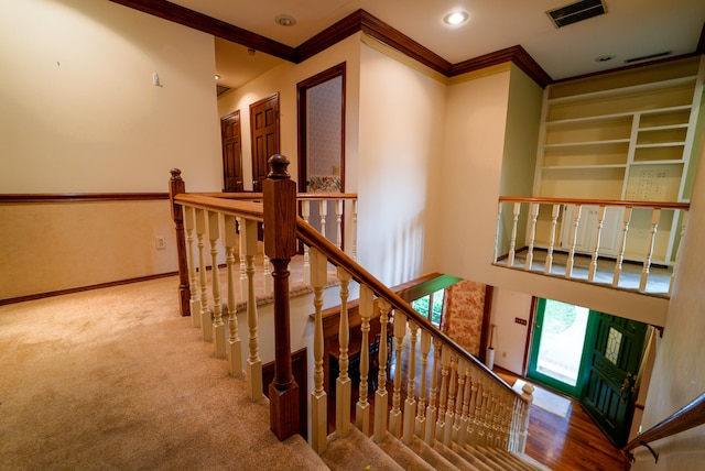 stairs with carpet floors and ornamental molding