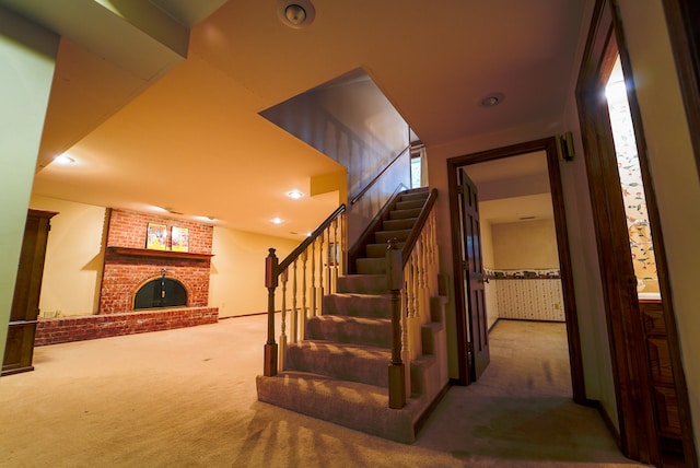 stairs featuring a fireplace and carpet flooring