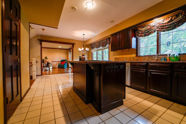 kitchen featuring pendant lighting, dark brown cabinetry, a chandelier, and light tile patterned floors