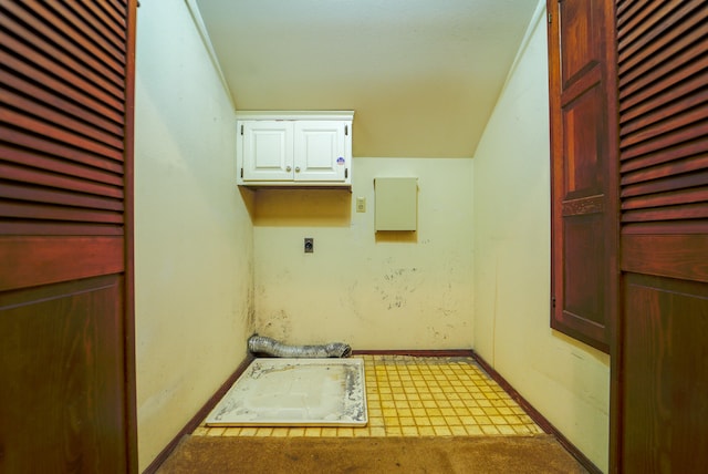 clothes washing area with light colored carpet, cabinets, and hookup for an electric dryer