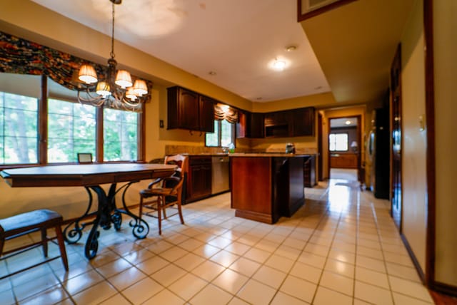 kitchen with pendant lighting, light tile patterned floors, an inviting chandelier, and a center island