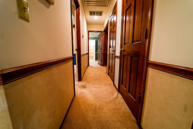 hallway featuring light colored carpet