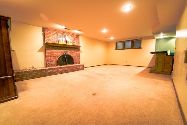 unfurnished living room with a brick fireplace and carpet