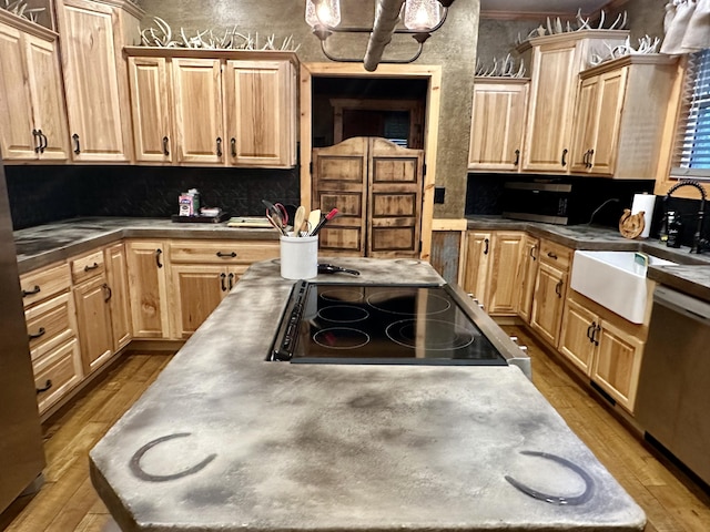 kitchen with light hardwood / wood-style floors, light brown cabinets, stainless steel dishwasher, and black stove