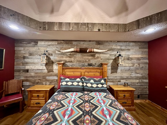 bedroom with wood-type flooring and wooden walls