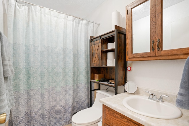 bathroom featuring toilet, walk in shower, vanity, and a textured ceiling