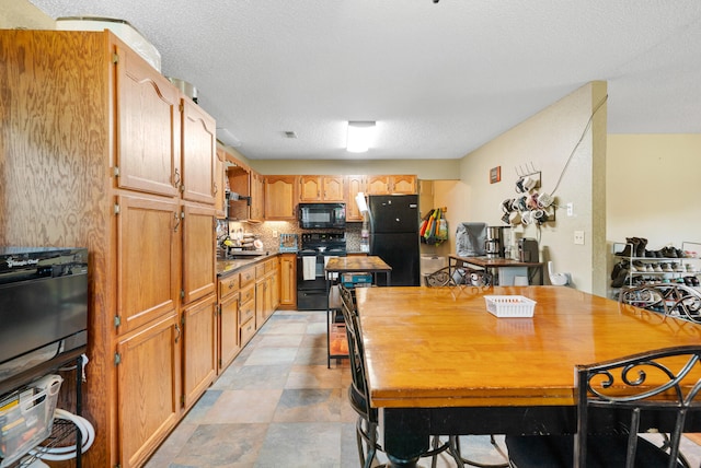 kitchen featuring decorative backsplash, black appliances, and a textured ceiling