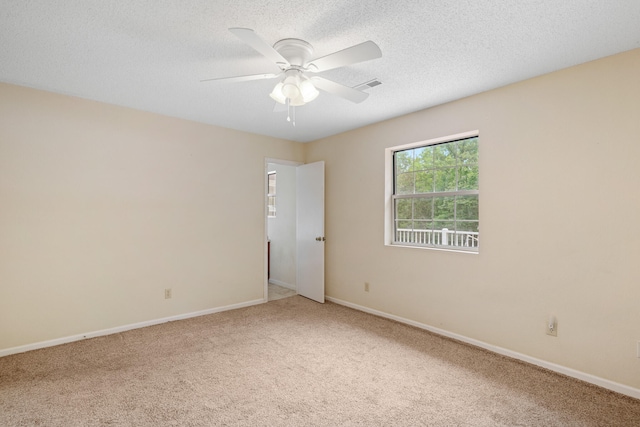 empty room featuring ceiling fan, carpet, and a textured ceiling