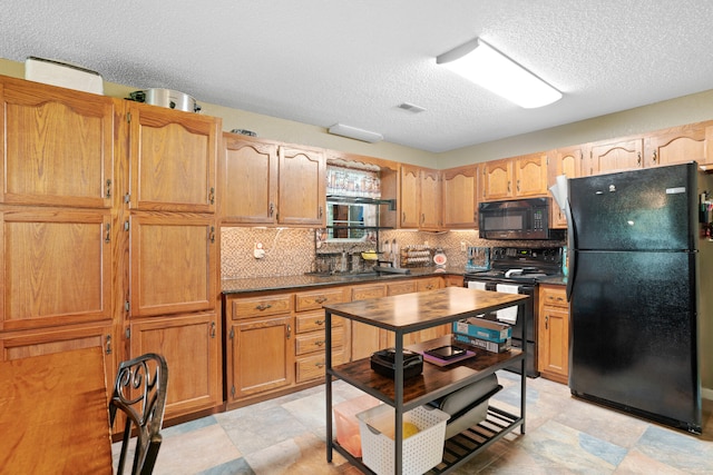 kitchen featuring a textured ceiling, backsplash, sink, and black appliances