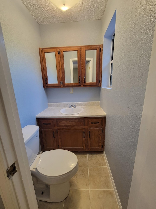 bathroom featuring vanity, toilet, and a textured ceiling