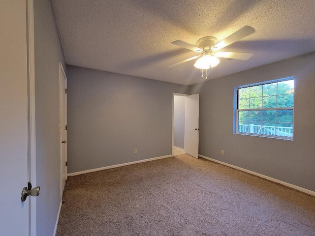 spare room featuring carpet floors, a textured ceiling, and ceiling fan